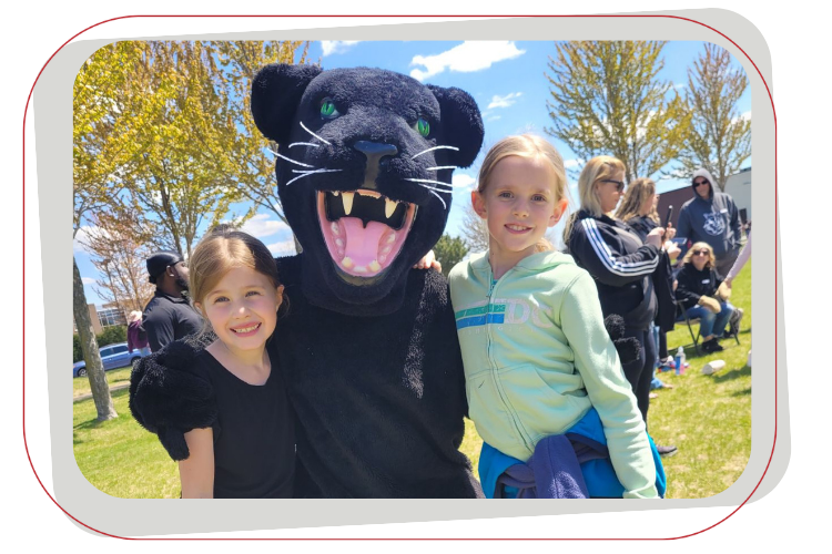 two female students with a panther mascot